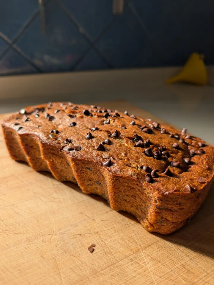 Banana bread amb xips de xocolata sobre una taula de fusta