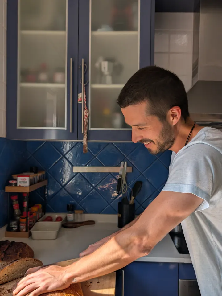 El panadero cortando hogazas recién hechas junto al azulejo azul