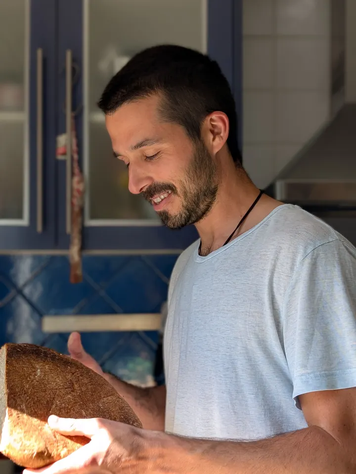 El forner sosté un pa acabat de coure i somriu